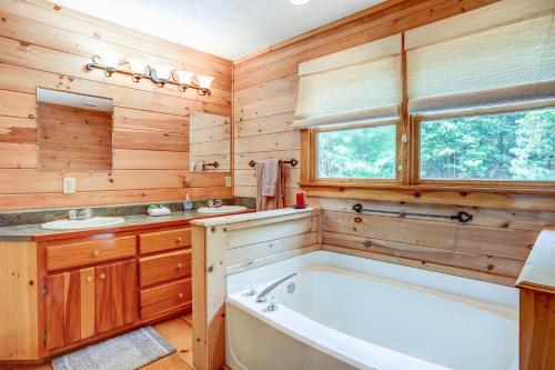 ein Holzbadezimmer mit einer Badewanne, 2 Waschbecken und einer Badewanne in der Unterkunft Cabin Hideaway in Ellijay