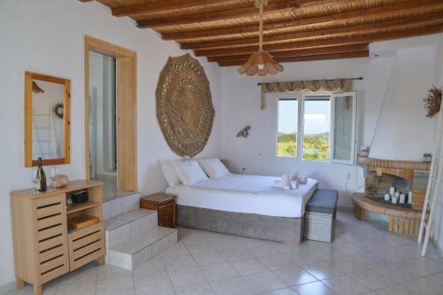 a bedroom with a large bed and a fireplace at XALAKAS SUMMER HOUSE in Empourios