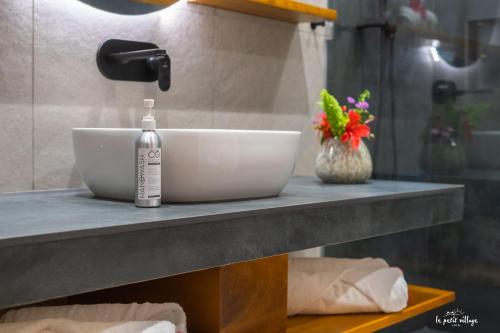 a sink and a bottle on a counter in a bathroom at Le Petit Village Boutique Hotel & Spa in Kampala