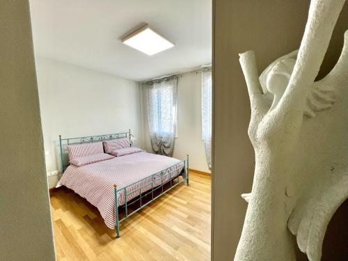 ERMAN HOUSE - Naviglio Riviera del Brenta Venezia في دولو: غرفة نوم بسرير وشجر