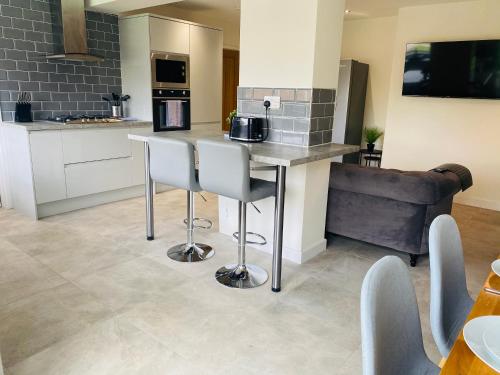 a kitchen with a counter and stools in a room at Modern Family Home with Off-Road Parking in Cardiff