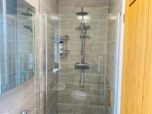 a shower with a glass door in a bathroom at Modern Family Home with Off-Road Parking in Cardiff