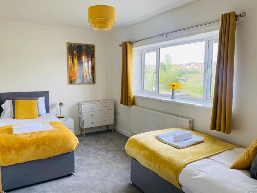 a bedroom with two beds and a window at Modern Family Home with Off-Road Parking in Cardiff