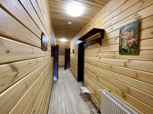 a hallway in a log cabin with wooden walls at Готель Довбуш in Yaremche