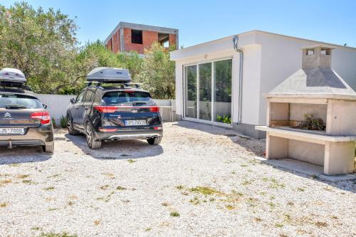 two cars parked in front of a house at Apartments Zdeslav in Rogoznica