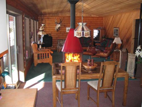 a living room with a table with a fireplace in it at Kamloops Log Home Bed and Breakfast in Kamloops