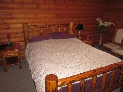 a bedroom with a wooden bed in a cabin at Kamloops Log Home Bed and Breakfast in Kamloops