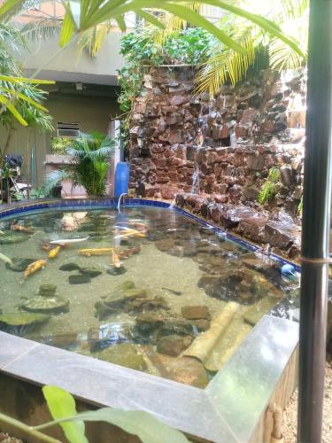 a swimming pool with a water fountain in a yard at SALATA Hotel CENTRO in Jardinópolis
