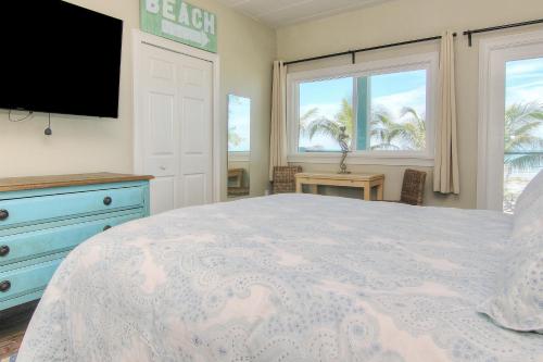 a bedroom with a bed and a tv and windows at Bungalow Beach Place 7 in Clearwater Beach