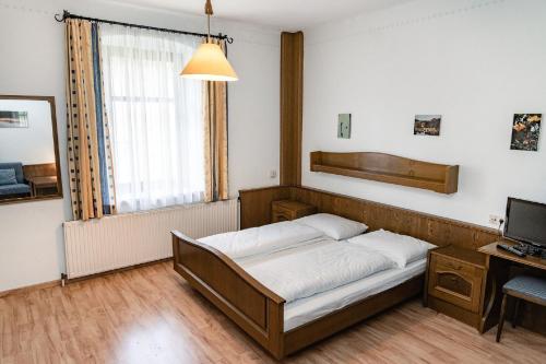 a bedroom with a bed and a desk and a television at Gasthof Filzwieser in Mitterbach