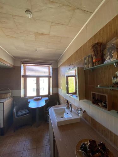 a kitchen with a sink and a table in a room at Comfortable apartment with fireplace in the Old Town in Narva