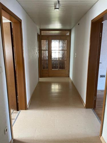 an empty hallway with a door and a window at Monteurswohnung Schwarzwald in Eggingen