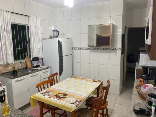 a kitchen with a table and a refrigerator at Lar Doce mar in Mongaguá