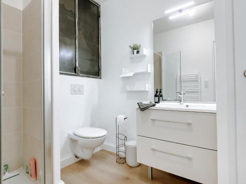 une salle de bain blanche avec des toilettes et un lavabo dans l'établissement Appartement type industriel dans cadre provençal, à Sanary-sur-Mer
