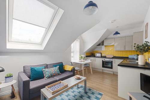 a living room with a couch and a kitchen at Albany 2 by Black Door Stays in Cardiff