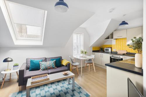 a living room with a couch and a kitchen at Albany 2 by Black Door Stays in Cardiff