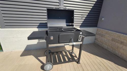 a barbecue grill on a stand in front of a building at Villa Leola in Ližnjan