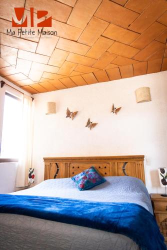 a bedroom with a bed with birds on the ceiling at Ma Petite Maison in Tepoztlán