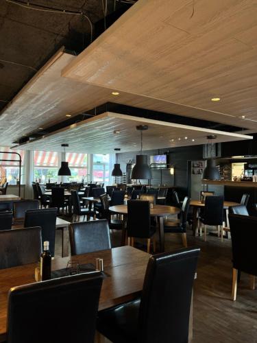 a dining room with wooden tables and chairs at Hotel Nordica Strömsund in Strömsund