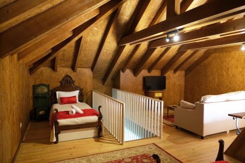 a attic bedroom with a bed and a couch at Aldeia da Quinta do Paço in Santo Tirso