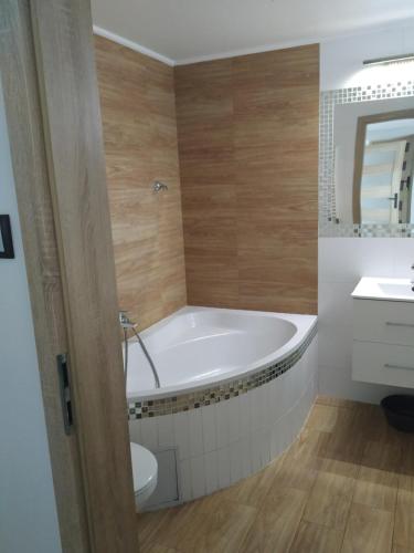 a bathroom with a tub and a sink at APARTAMENT OSTROWO 1 in Ostrowo