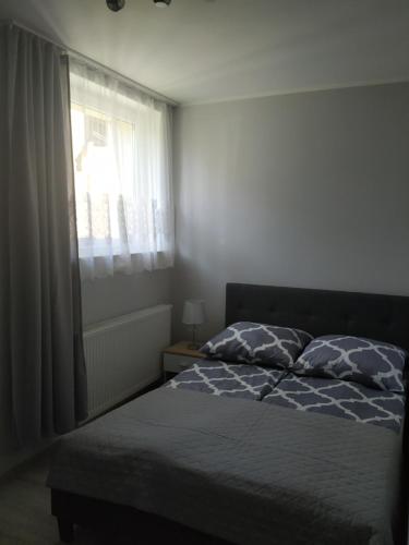 a bedroom with a bed and a window at APARTAMENT OSTROWO 1 in Ostrowo
