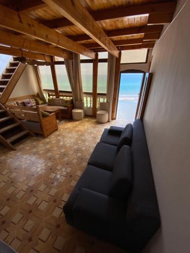 a living room with a couch and a view of the ocean at Single fin beach house in Taghazout