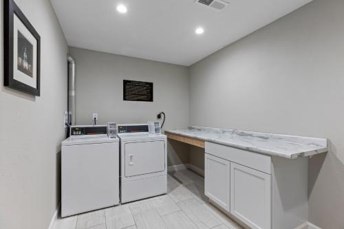 a white laundry room with a washer and dryer at Comfort Inn & Suites St Louis-Hazelwood in Hazelwood