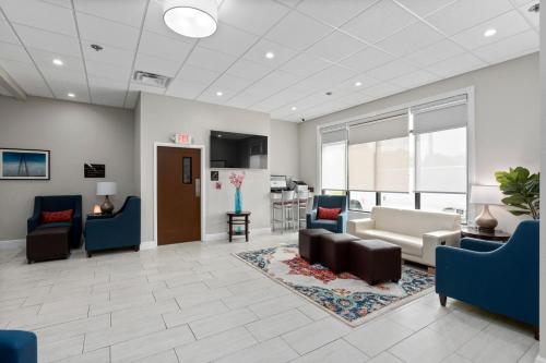 a lobby with couches and chairs and a kitchen at Comfort Inn & Suites St Louis-Hazelwood in Hazelwood