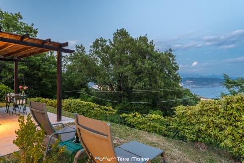 a patio with chairs and a table and a view of the water at Villa Ca Damare, TerreMarine in Le Grazie