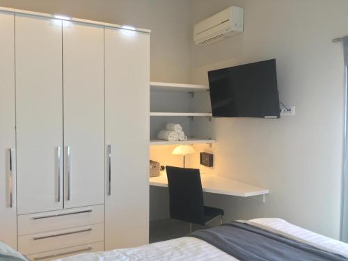 a bedroom with a bed and a desk with a monitor at High View-A Seaside Villa With Huge Jacuzzi in Račišće