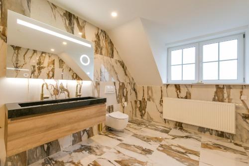 a bathroom with a sink and a toilet at The White House in Maria-Hoop