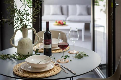 una mesa blanca con botellas de vino y copas. en Residence THE ONE - new en Komiža