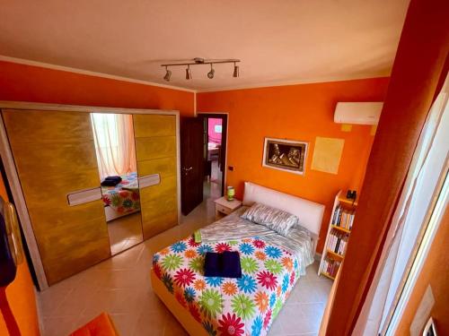 1 dormitorio con 1 cama en una habitación con paredes de color naranja en Lalu's B&B, en Sorso