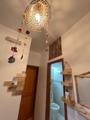 a bathroom with a chandelier and a toilet at We surf Morocco BOUTIQUE HOUSE in Taghazout