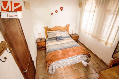 a bedroom with a bed with a wooden headboard at Ma Petite Maison in Tepoztlán
