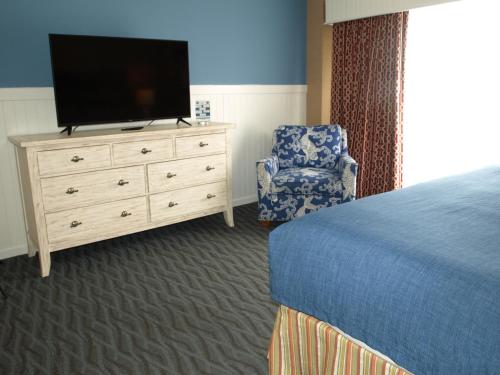 a bedroom with a bed and a tv and a chair at Avenue Inn & Spa in Rehoboth Beach