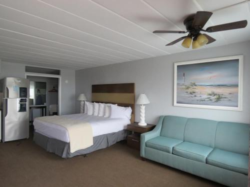 a bedroom with a bed and a couch and a ceiling fan at Granada Ocean Resort in Wildwood Crest