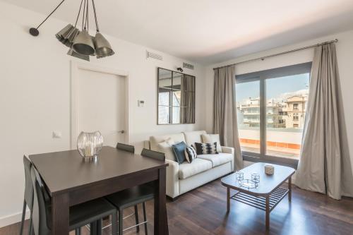 a living room with a couch and a table at Green-Apartments Sierpes Luxury Suites in Seville