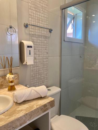 a bathroom with a toilet and a sink and a shower at Pousada Cabanas Rota do Sol in Gramado