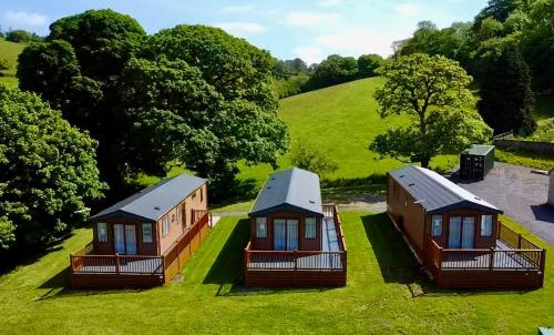 un grupo de cabañas en el césped en un campo en Lillypool Lodges en Cheddar