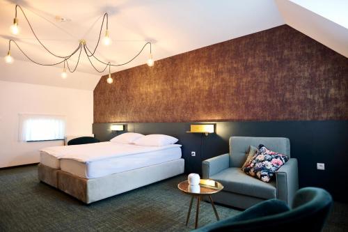 een hotelkamer met een bed en een bank bij Mokrice Castle Estate in Brežice
