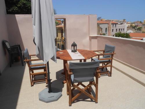 a wooden table with chairs and an umbrella on a balcony at Casa Dasyra in Chania Town