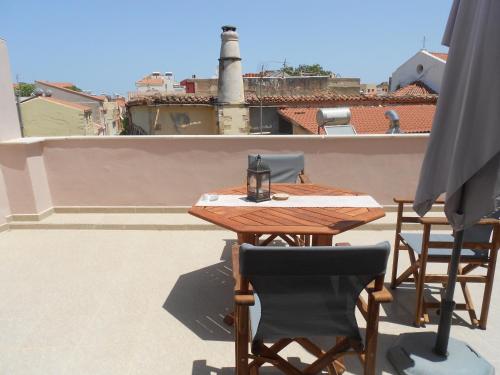 a wooden table and chairs on a roof at Casa Dasyra in Chania Town