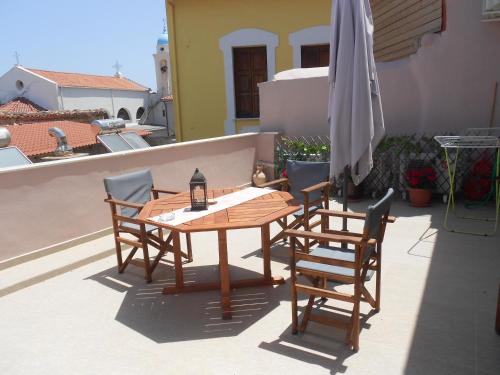 a wooden table and chairs on a patio with an umbrella at Casa Dasyra in Chania Town