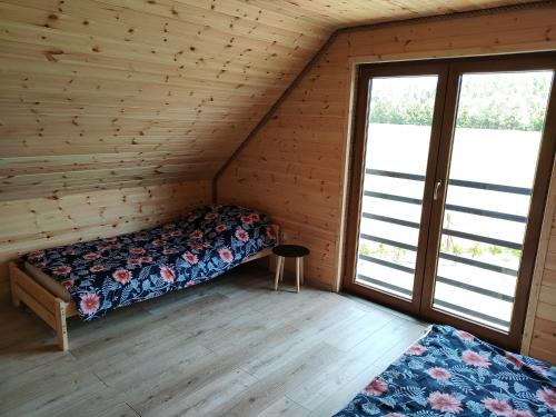 1 dormitorio con 2 camas en una casa de madera en Domek u Lipków na Kaszubach "Oliś" JACUZZI, en Gostomko