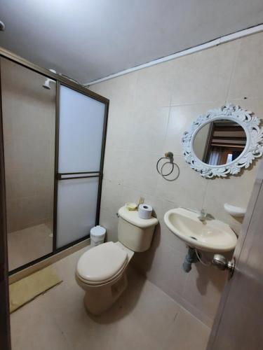 a bathroom with a toilet and a sink and a mirror at Hotel Recreacional Marcelandia Santa Rosa de Cabal in Santa Rosa de Cabal