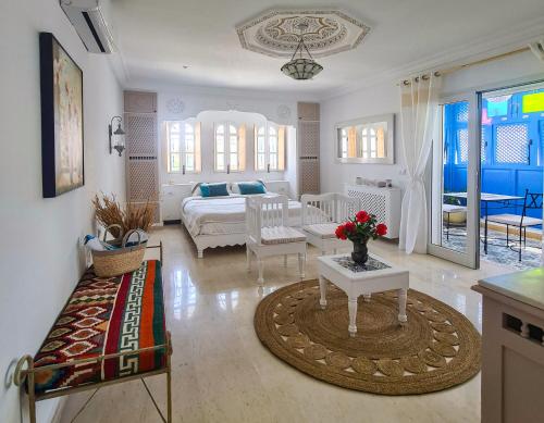 Sala de estar amplia con cama y mesa en Dar Colibri - Maison d'hôtes à Kélibia en Kelibia