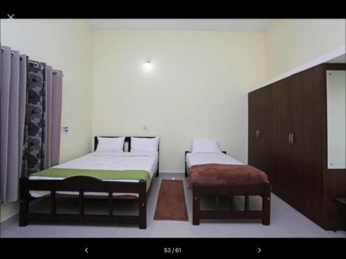 a room with two beds and a stool in it at Coorg North Breeze Homestay in Madikeri