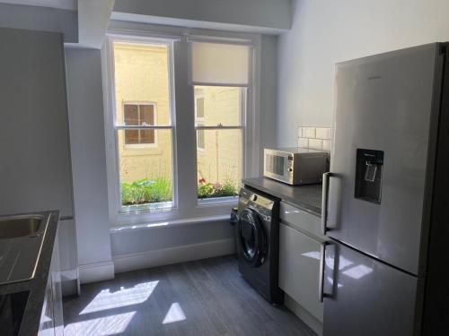 a kitchen with a refrigerator and a microwave at Promenade Apartment with own Beach Hut in Totland
